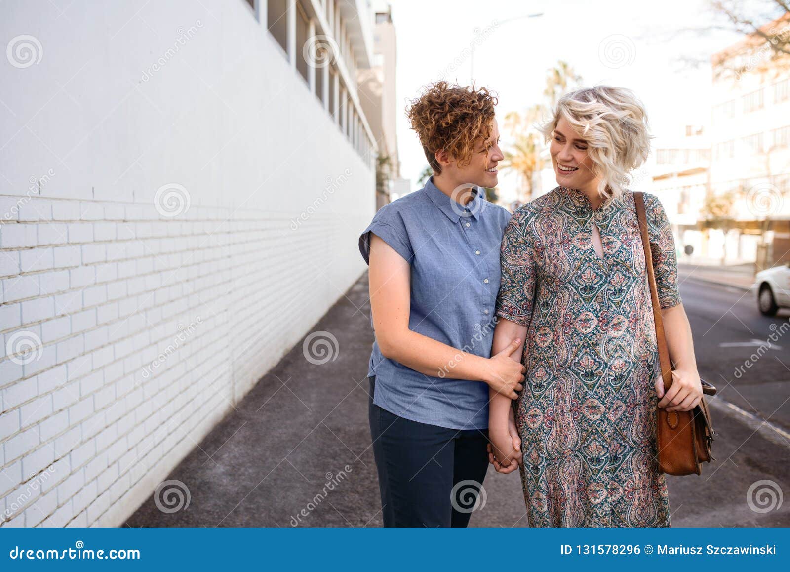 Smiling Lesbian Couple Walking Together In The City Holding Hands Stock