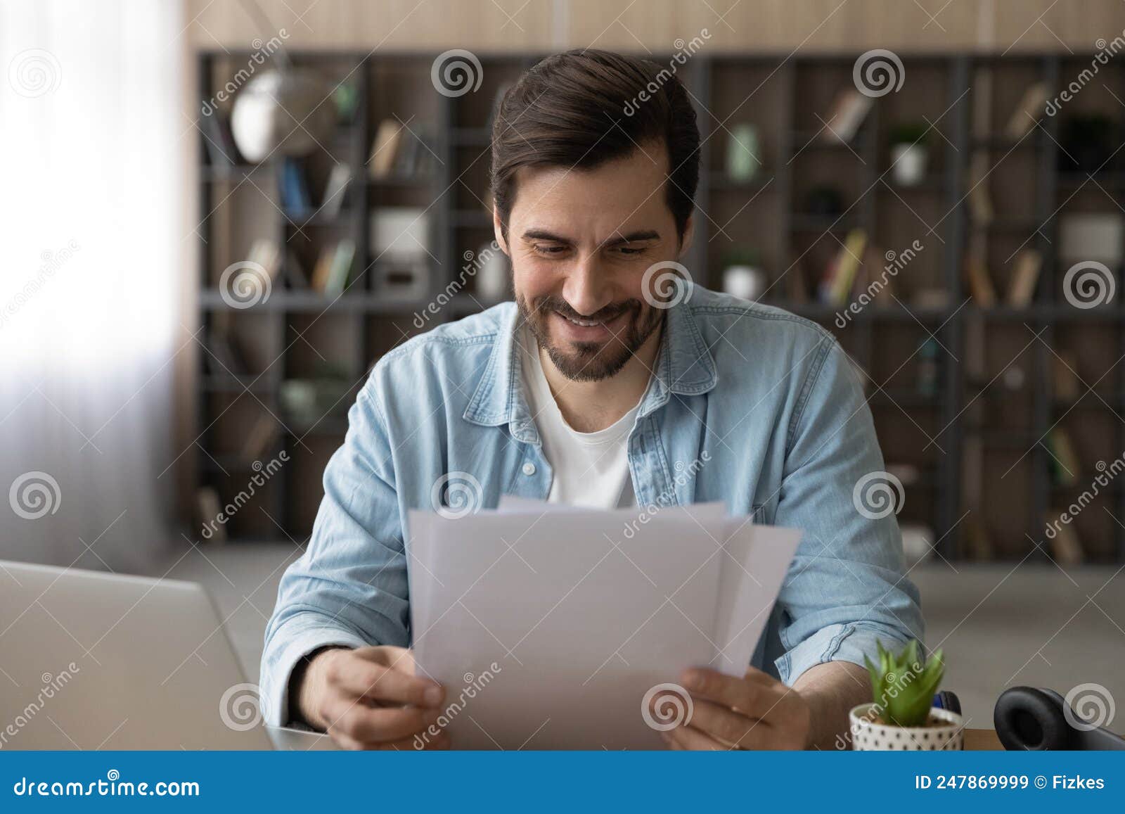 smiling young male remote employee receive paper letter of accreditation