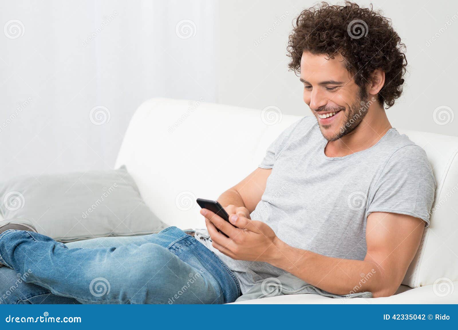 smiling young man holding cellphone