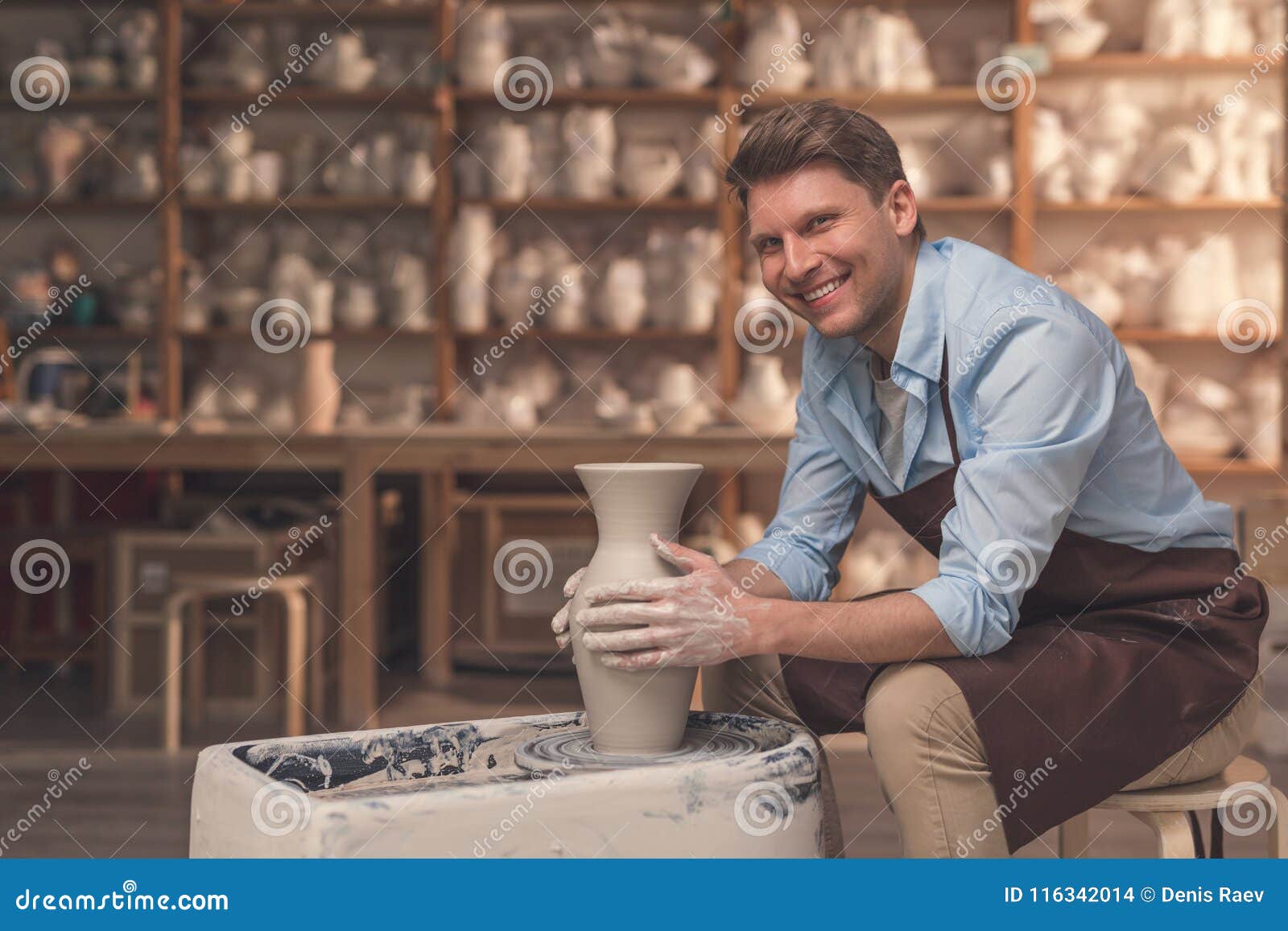 smiling man at the potter`s wheel