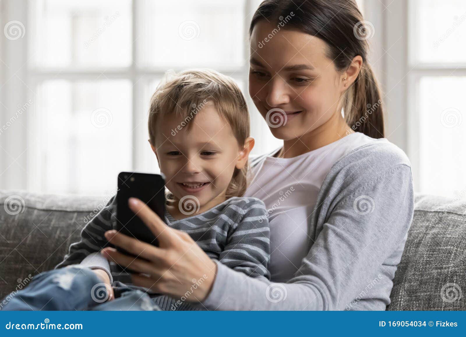 Young Mum and Little Son Watch Video on Cell Together Stock Photo - Image  of mother, cellphone: 169054034