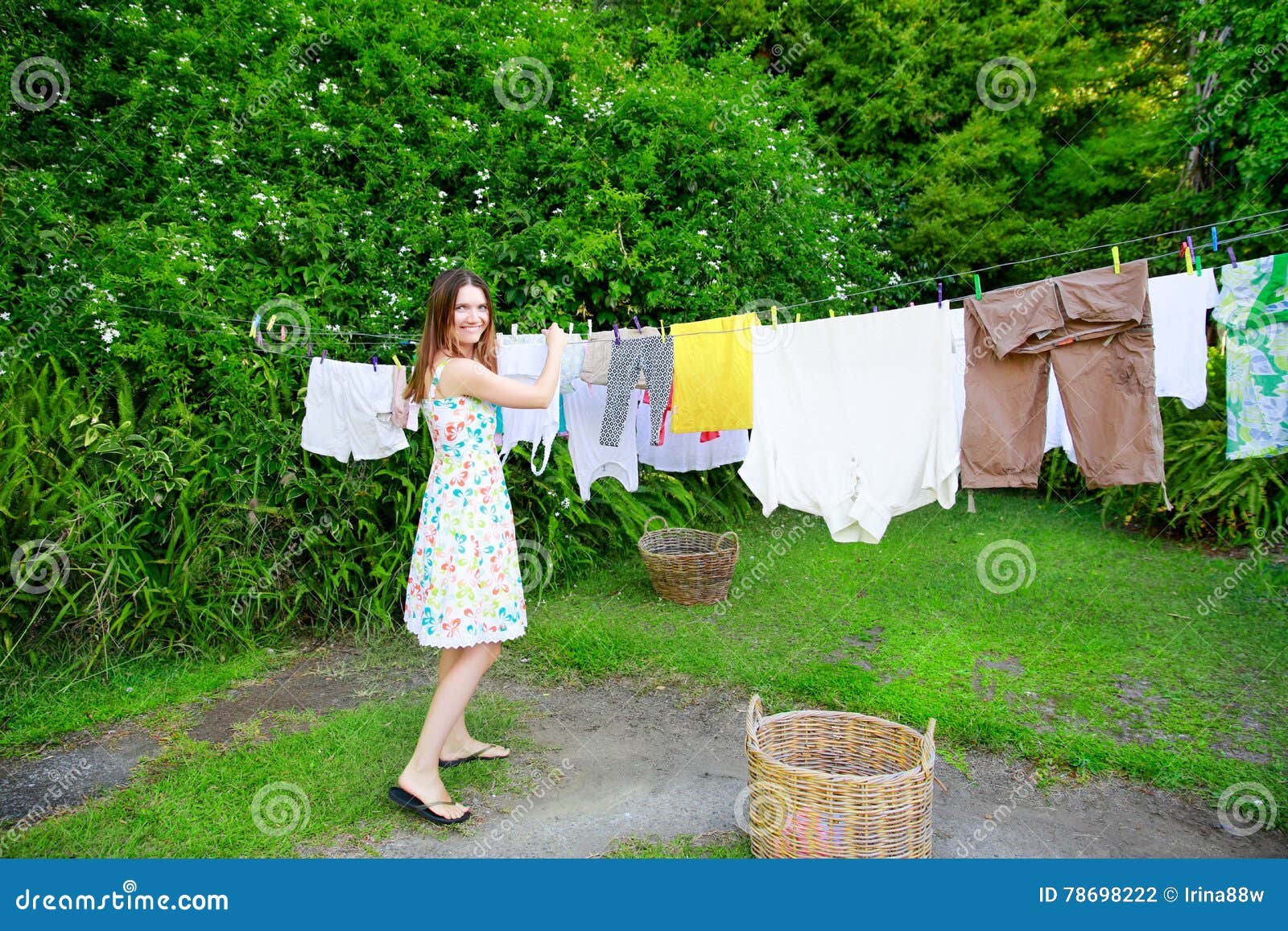 Smiling Young Woman in Colorful Dress Hanging Laundry on Clothesline at the  Backyard Stock Photo - Image of sheet, clothespin: 78698222