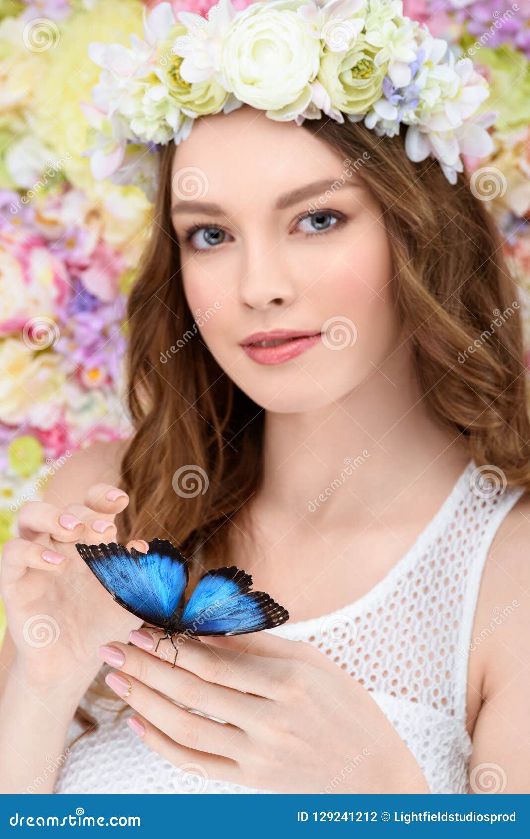 smiling young woman in floral wreath with butterfly