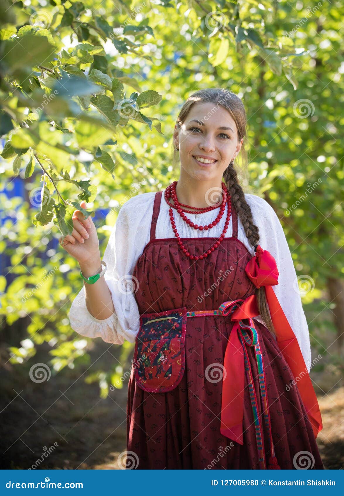Smiling Young Woman in Russian Folk Costume on the Foliage Background ...