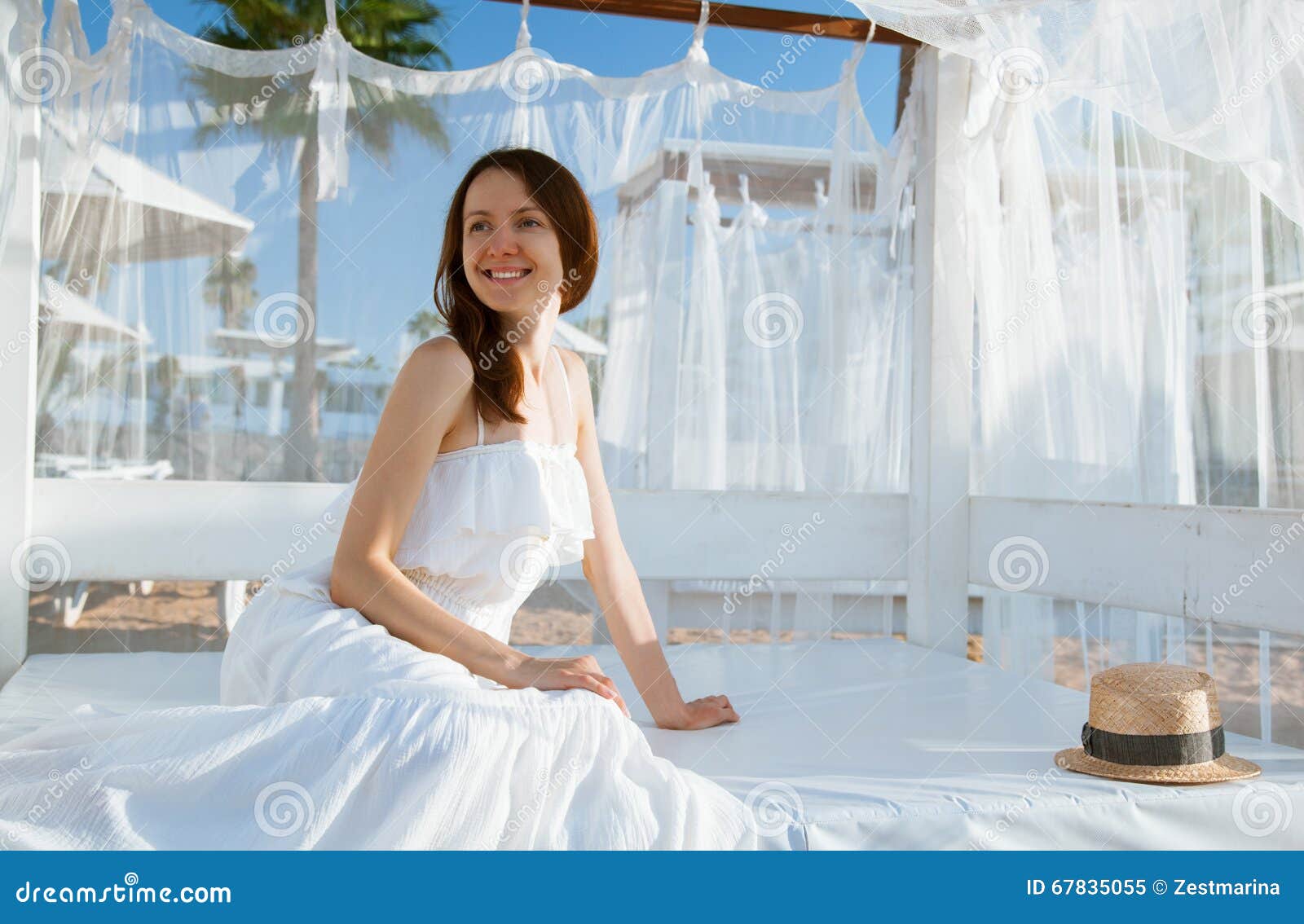 smiling young woman sitting under white baldachin