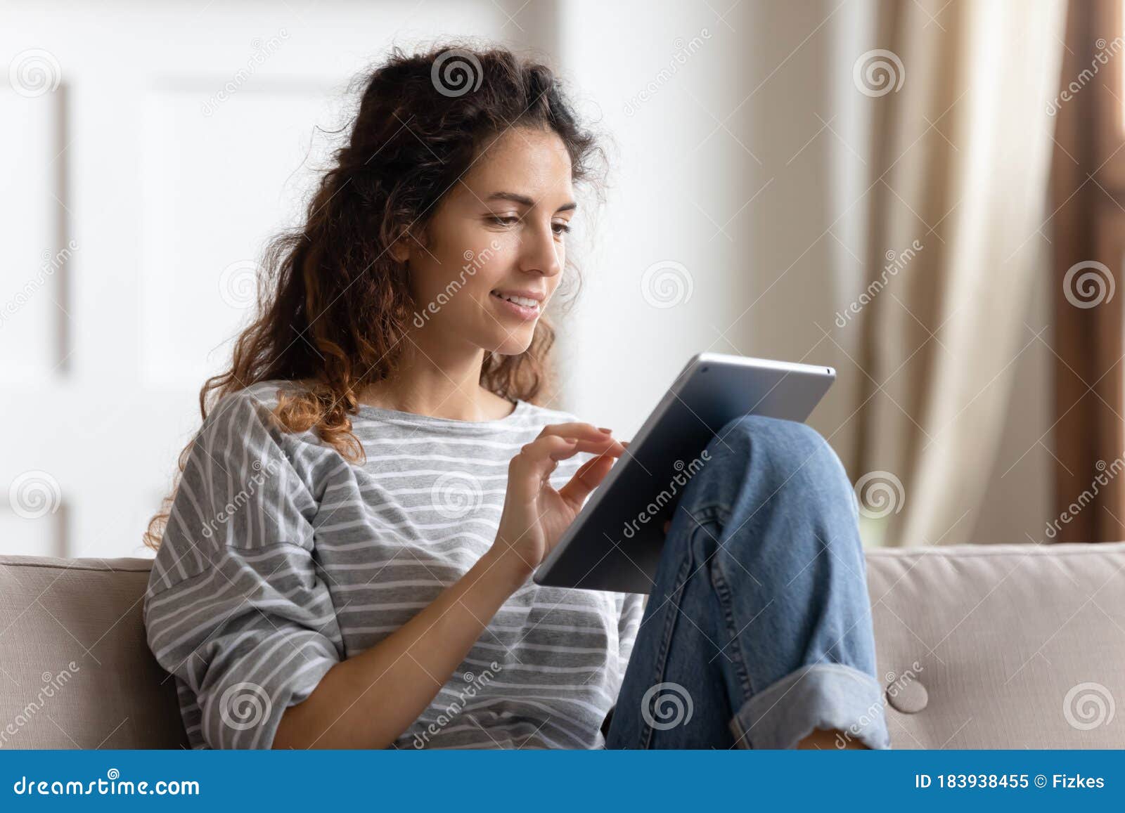 Smiling Young Woman Using Computer Tablet, Sitting on Couch Stock Image ...