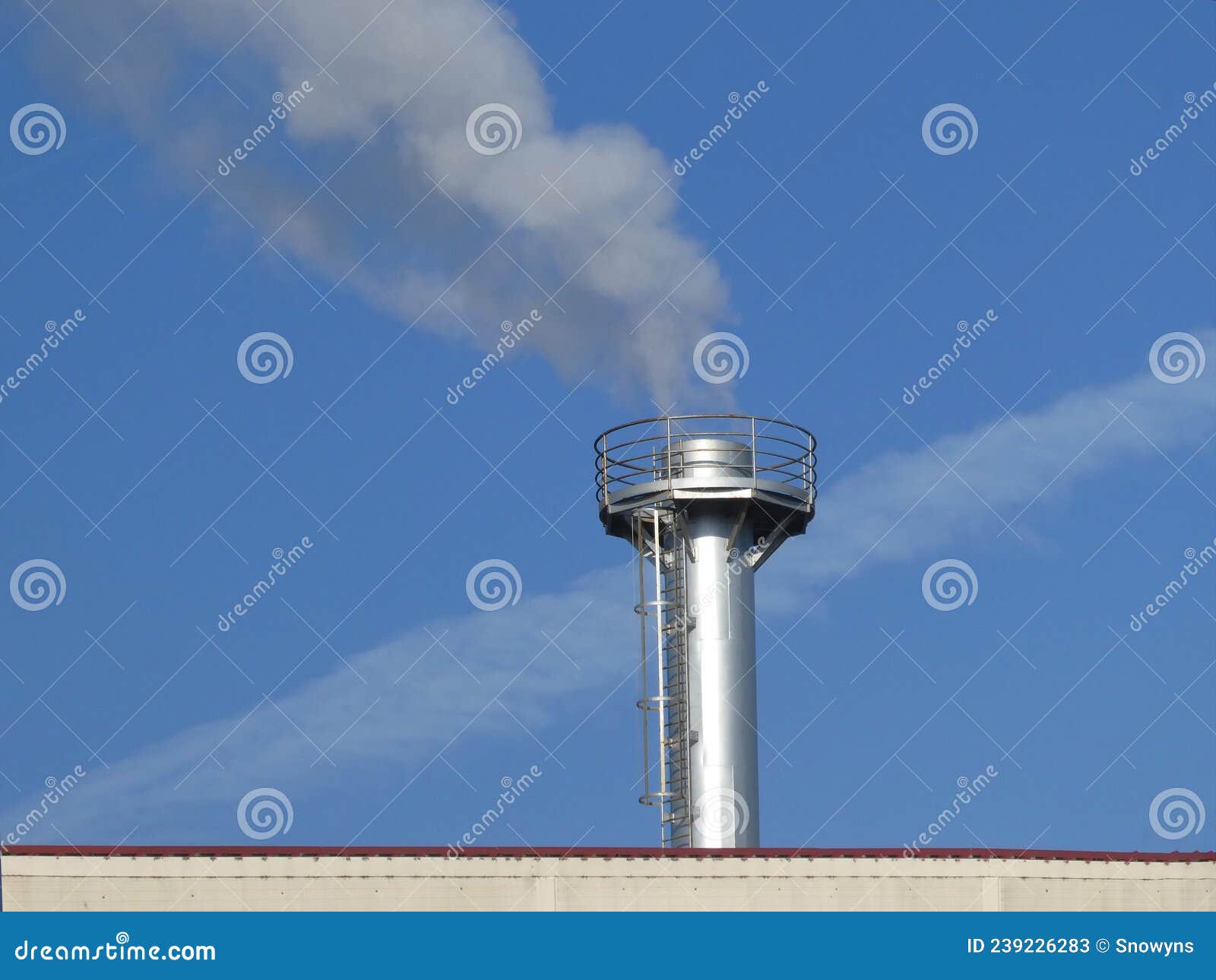 smoke spews out of a chimney on the roof at an industrial plant