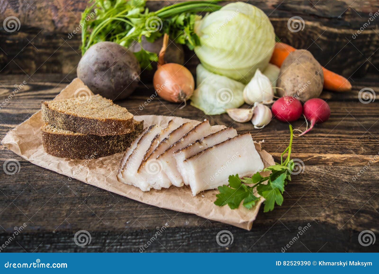 Smoked Lard with Bread and Vegetables in the Background. Wooden Rustic