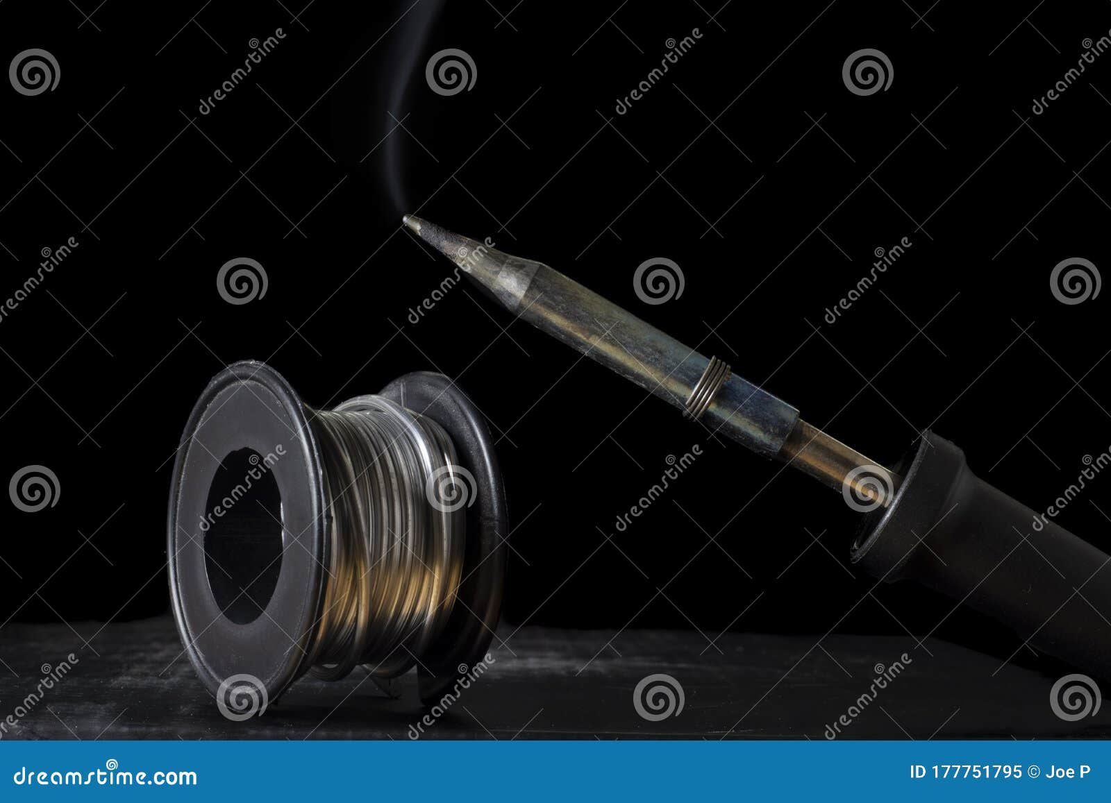 Smoky Soldering Iron and Solder Wire Bobbin on a Black Background Stock ...