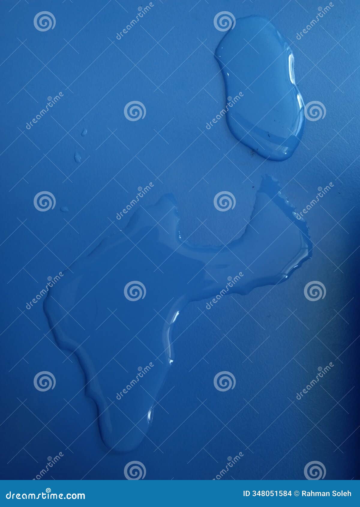 the smooth and shiny blue countertop contrasts with the darker water tracks, giving a wet and fresh feel. a few drops