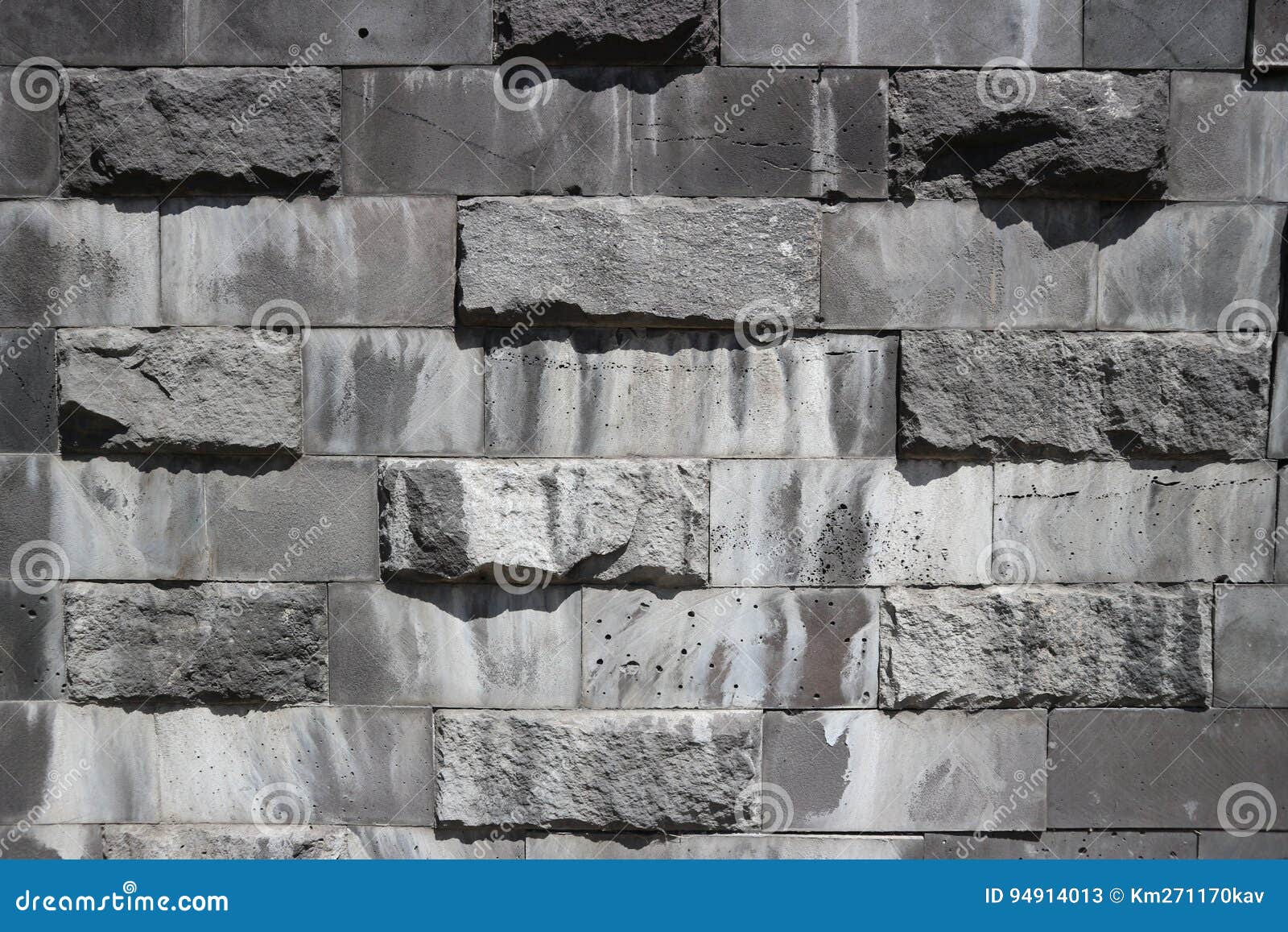 smooth and untreated gray rectangular granite stone wall, rubblework