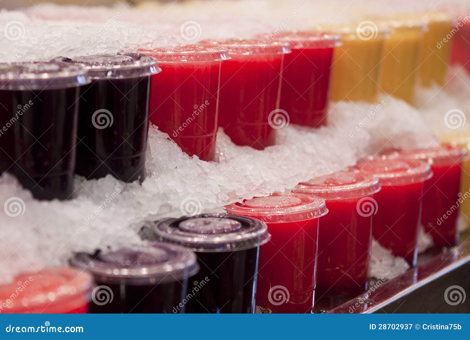 Los smoothies de la fruta arreglaron en una fila fresca con hielo