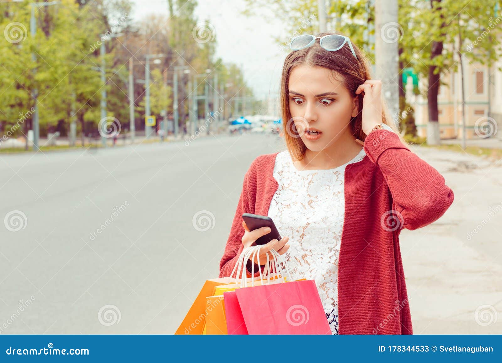 sms. closeup portrait funny shocked anxious scared young girl lady looking at phone seeing bad news photos bully message with