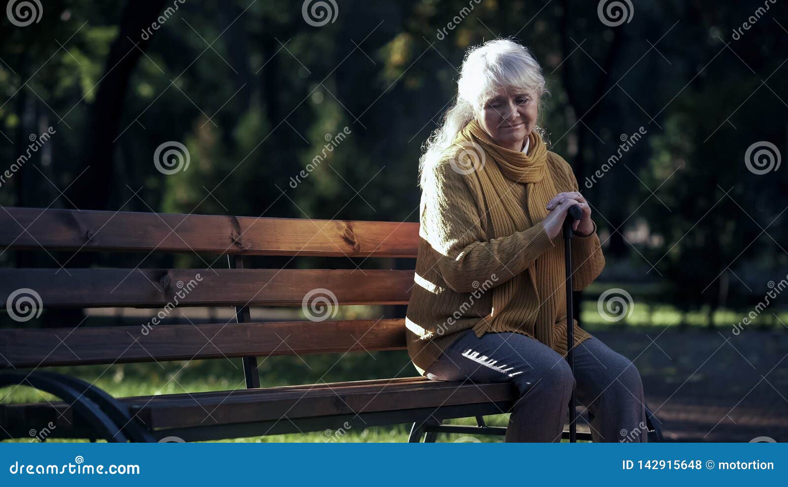 Smutny osamotniony starej kobiety obsiadanie na ławce w parku, zaniechani starsi ludzi samotnie, akcyjna fotografia