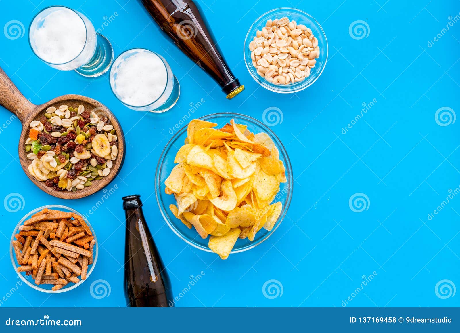 Snacks and Beer. Chips, Nuts, Rusks Near Beer on Blue Background Top