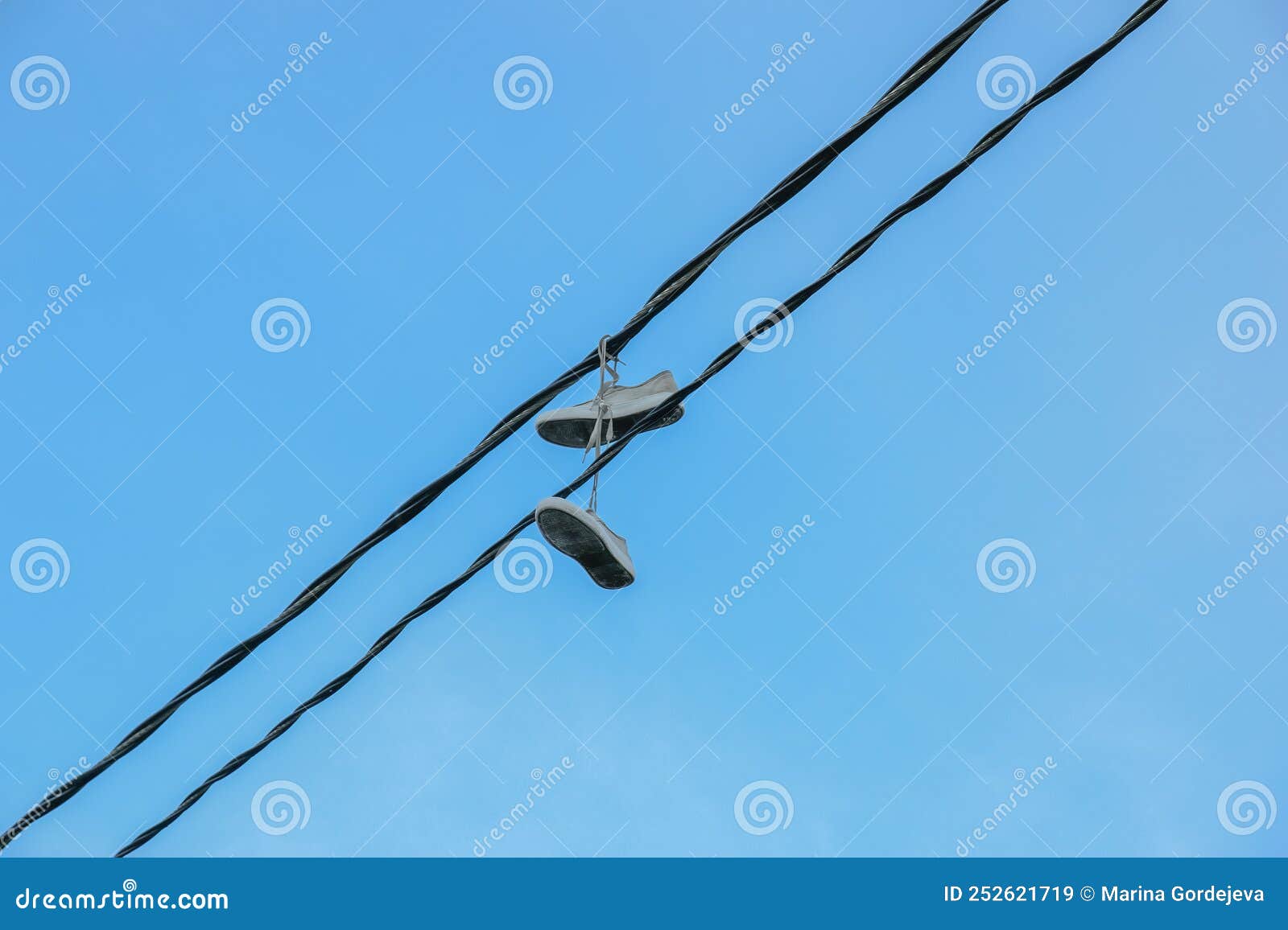 Several Pairs Of Shoes Tied Together Hang On A Power Line Stock Photo,  Picture and Royalty Free Image. Image 136751176.