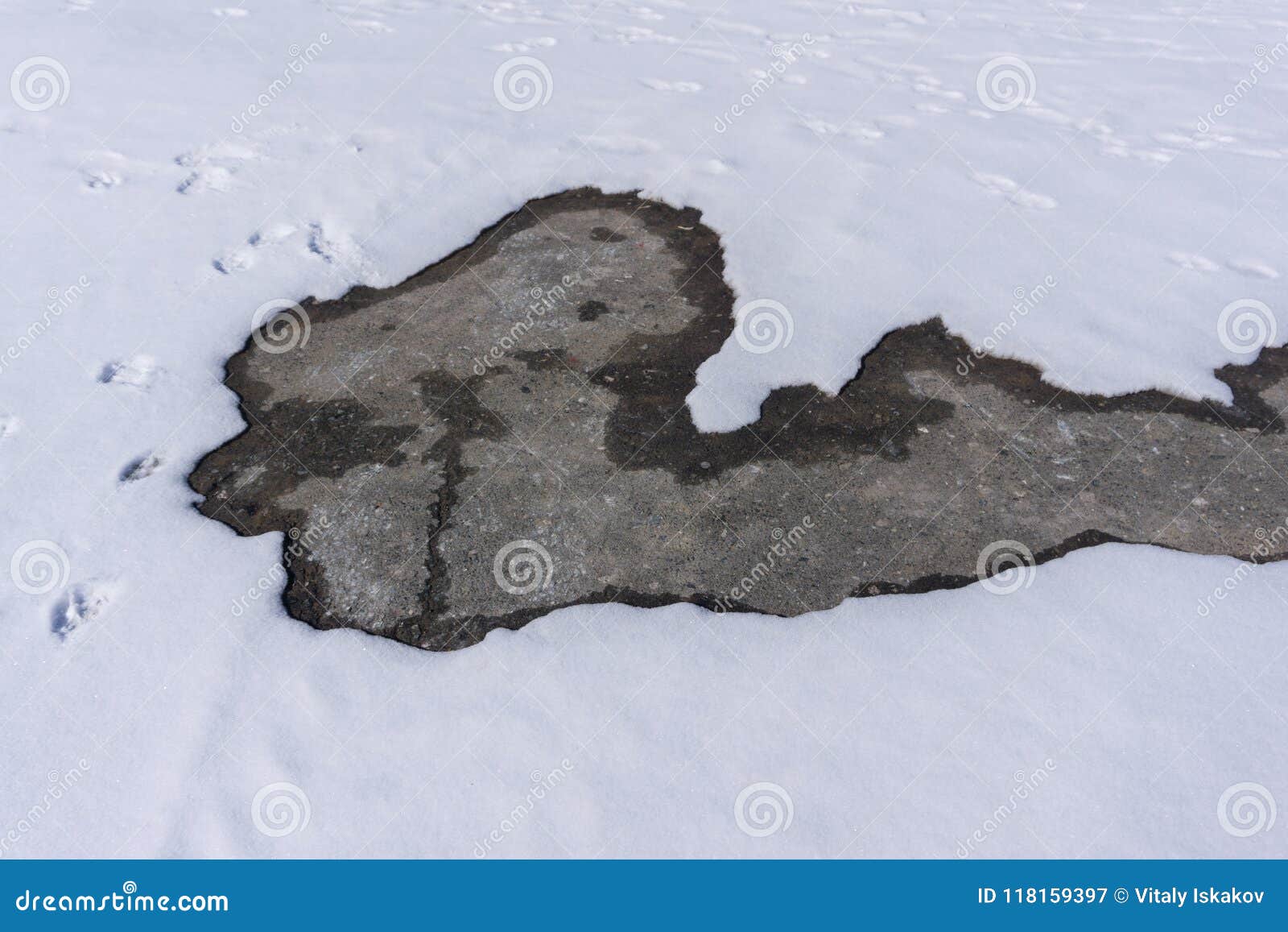 Snow on the Asphalt Melts Under the Rays of the Spring Sun . Stock