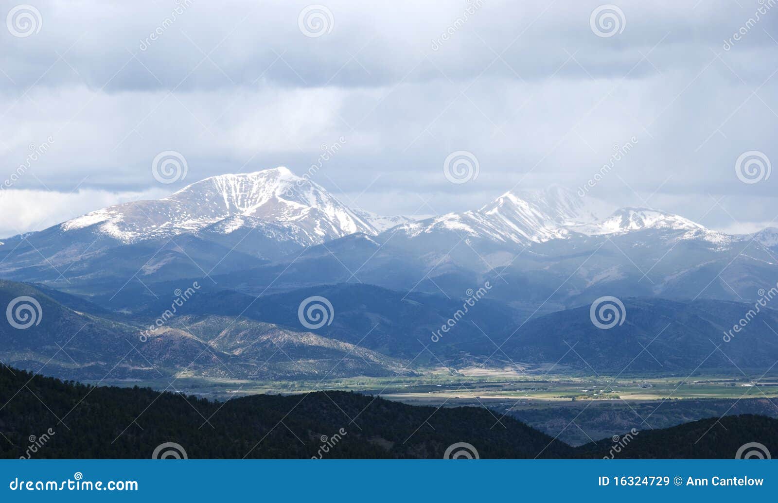 snow capped mountains shrouded in storm clouds