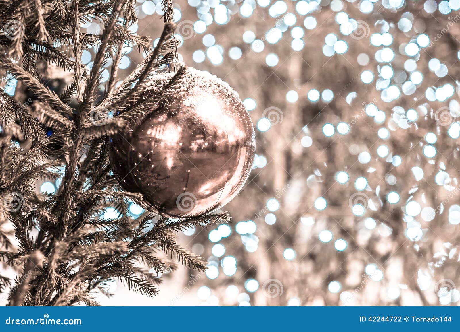snow covered decoration ball on a christmas tree. desaturated