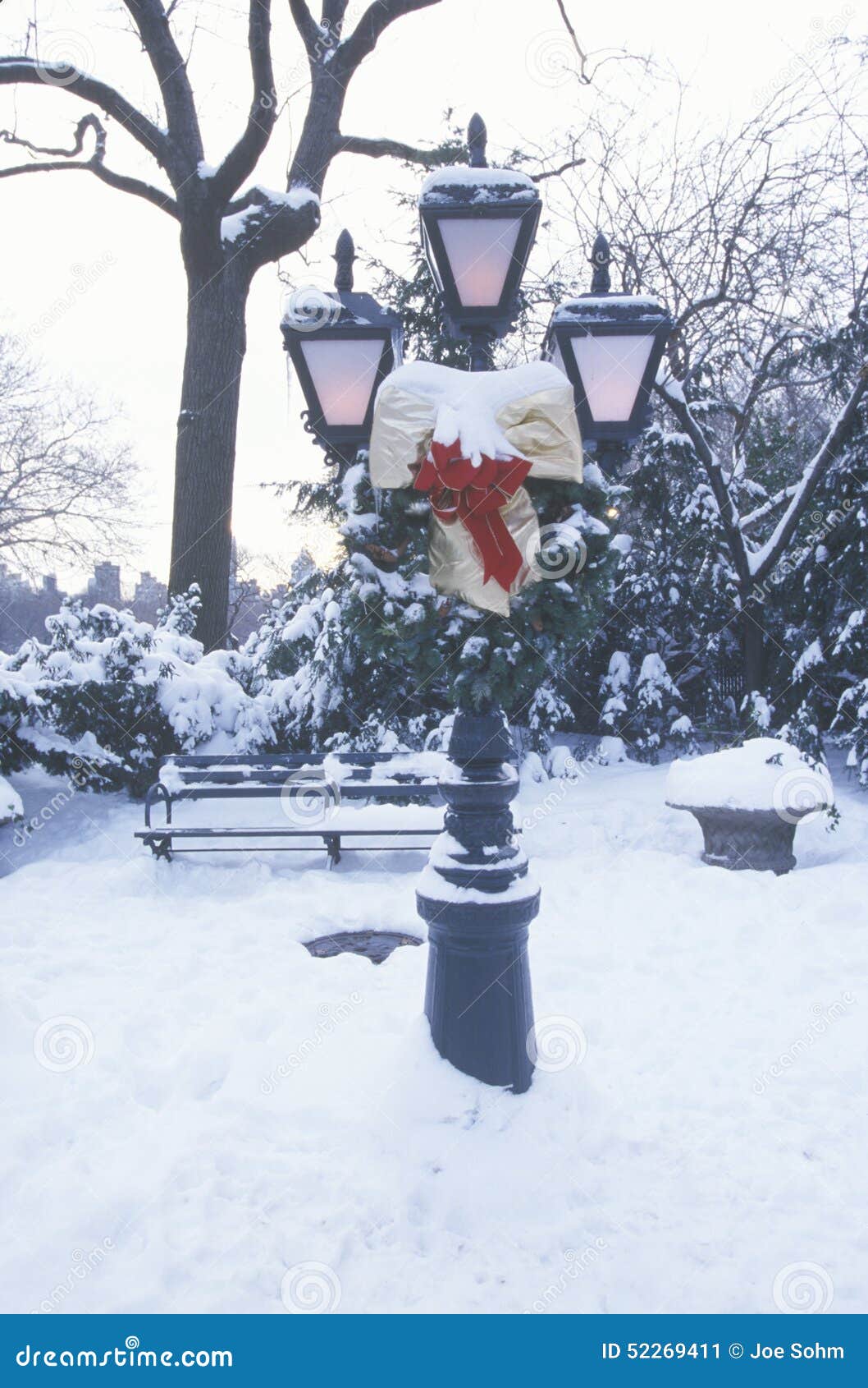 snow covered lampposts and christmas decor with fresh snow in central park, manhattan, ny