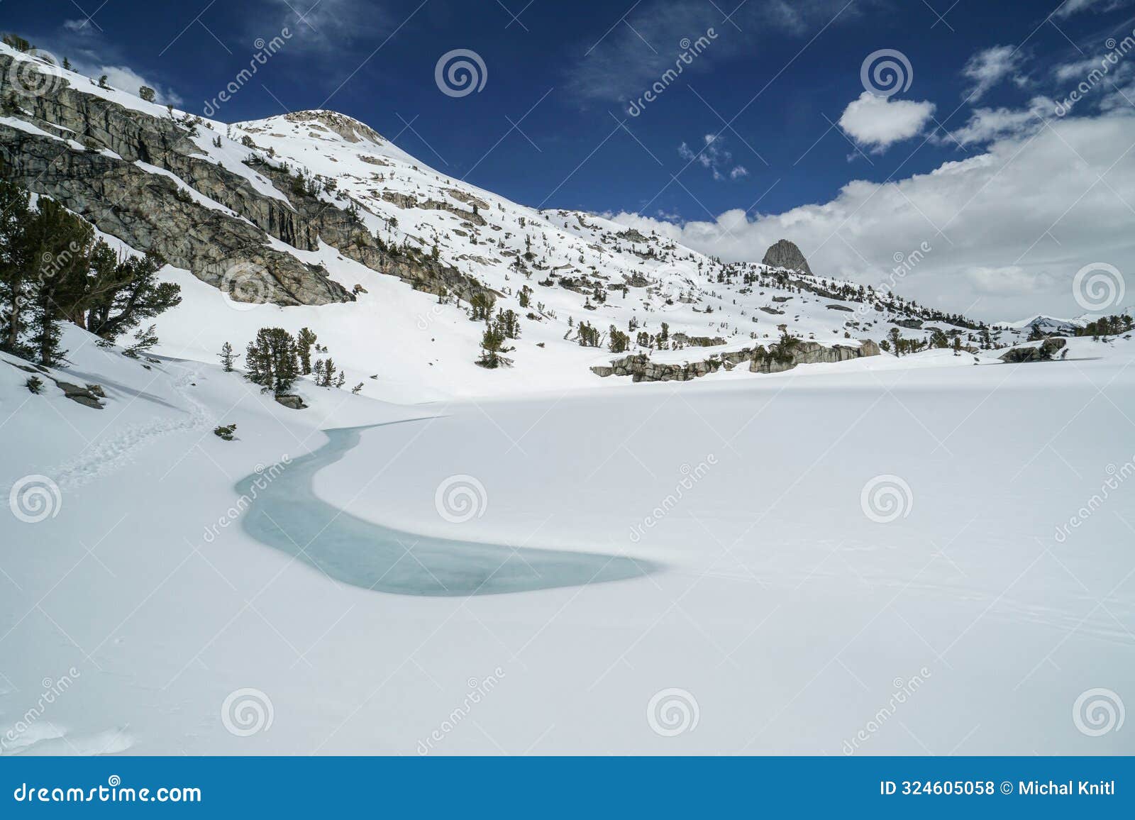 a snow covered mountain range with a small river running through it