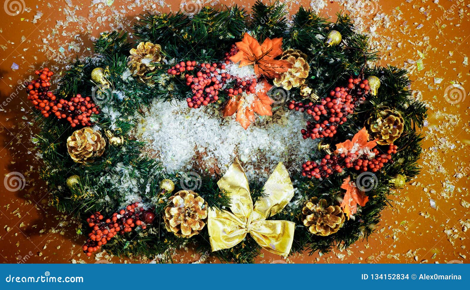 snow falling on thhe christmas wreath on the brown background