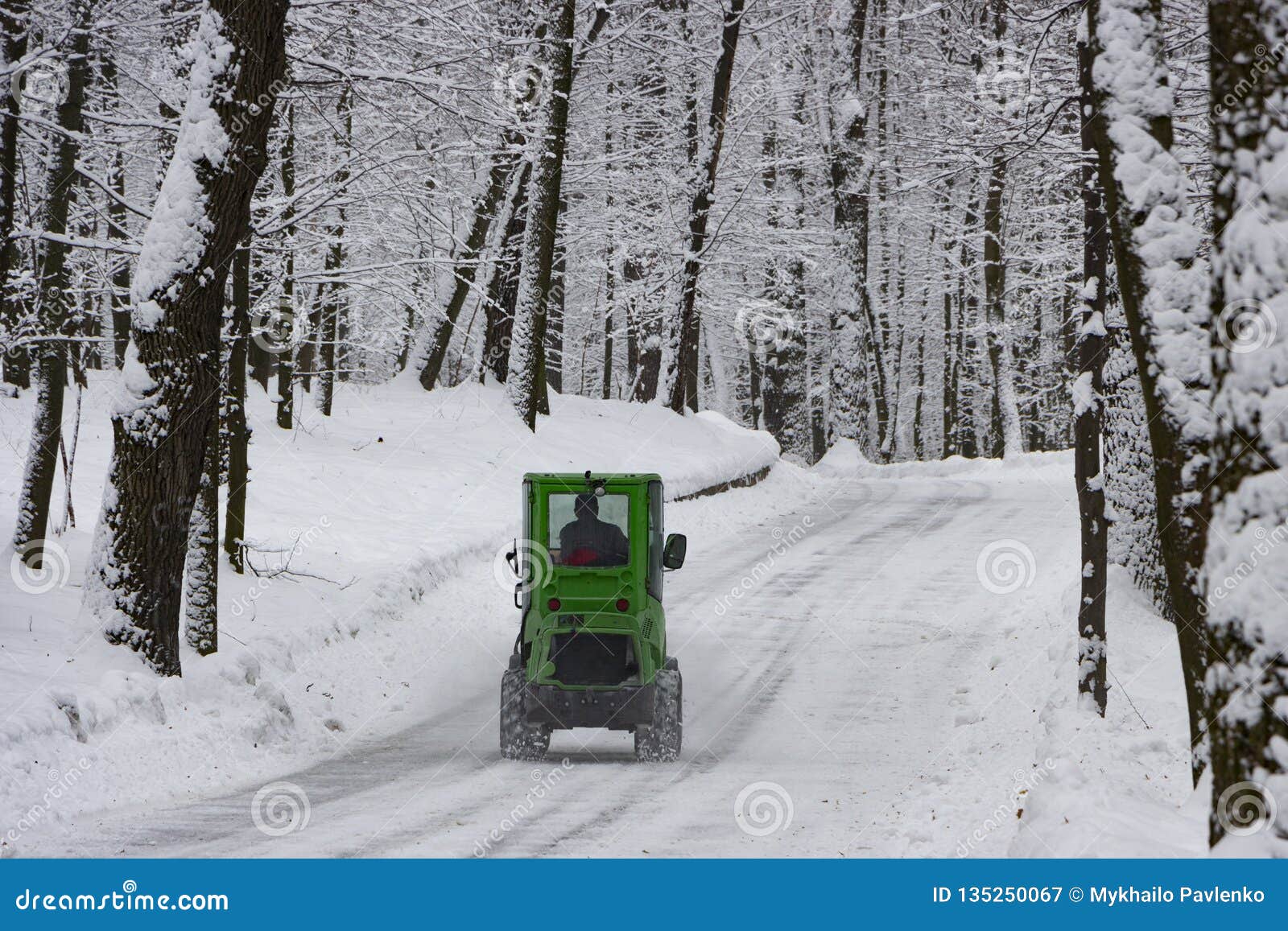 Snow Machine, Green Tractor Cleans the Snow from the Snow in the