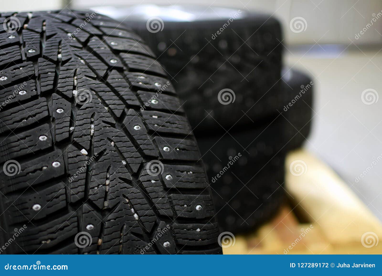 snow tires with metal studs in garage