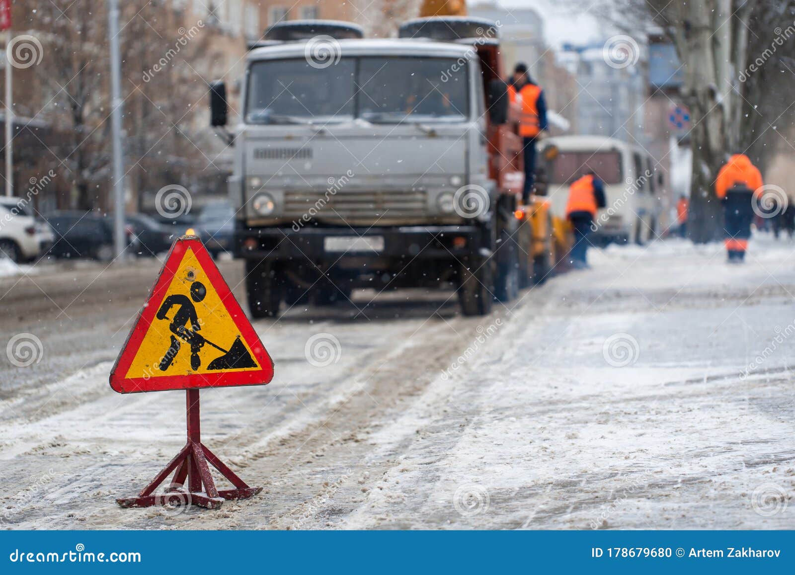 snowblower clear freezing winter road with snow and ice.snow-plow remove snow from the city street.warning road sign