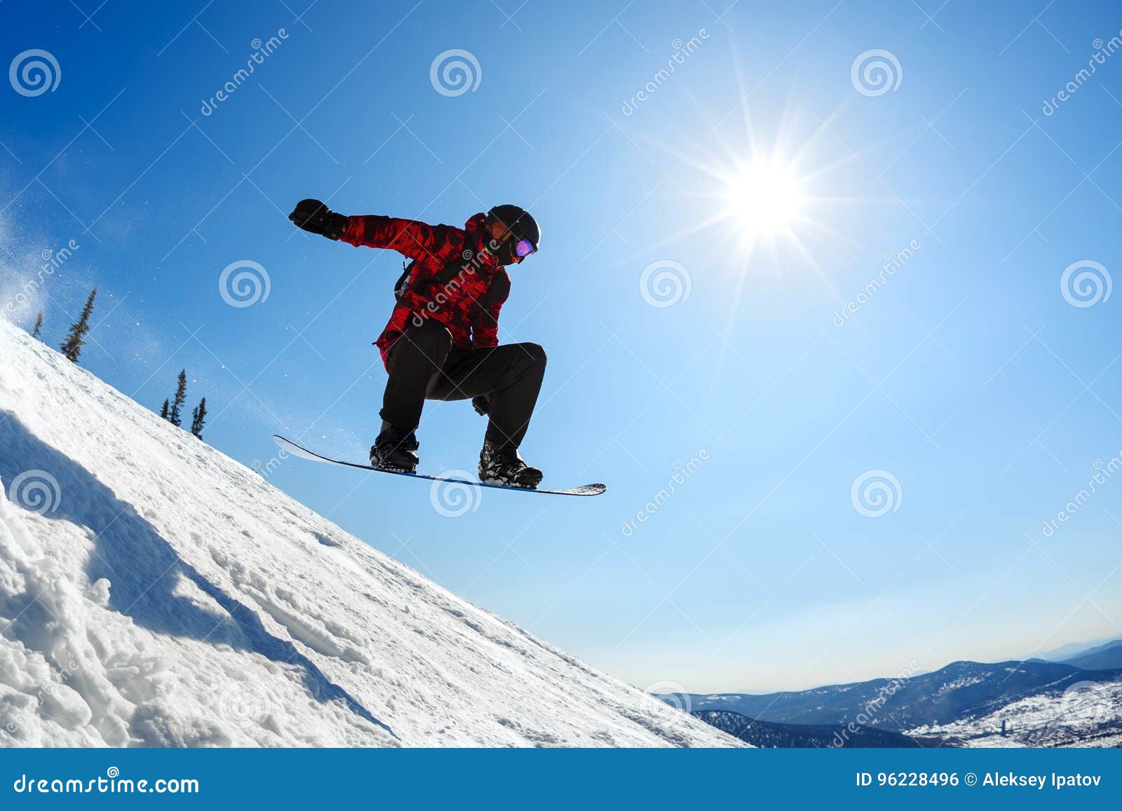 Snowboarder Jumping from the Springboard Against the Sky Stock Photo