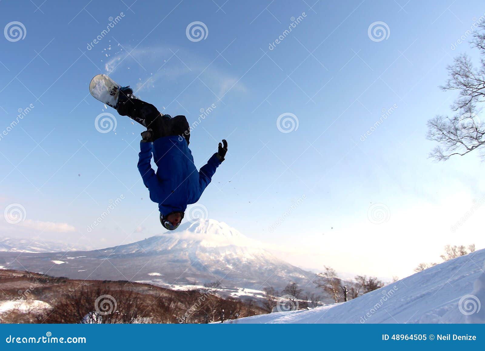snowboarder sending it off backcountry jump