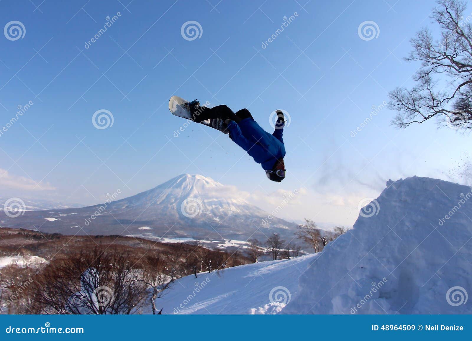 snowboarder sending it off backcountry jump