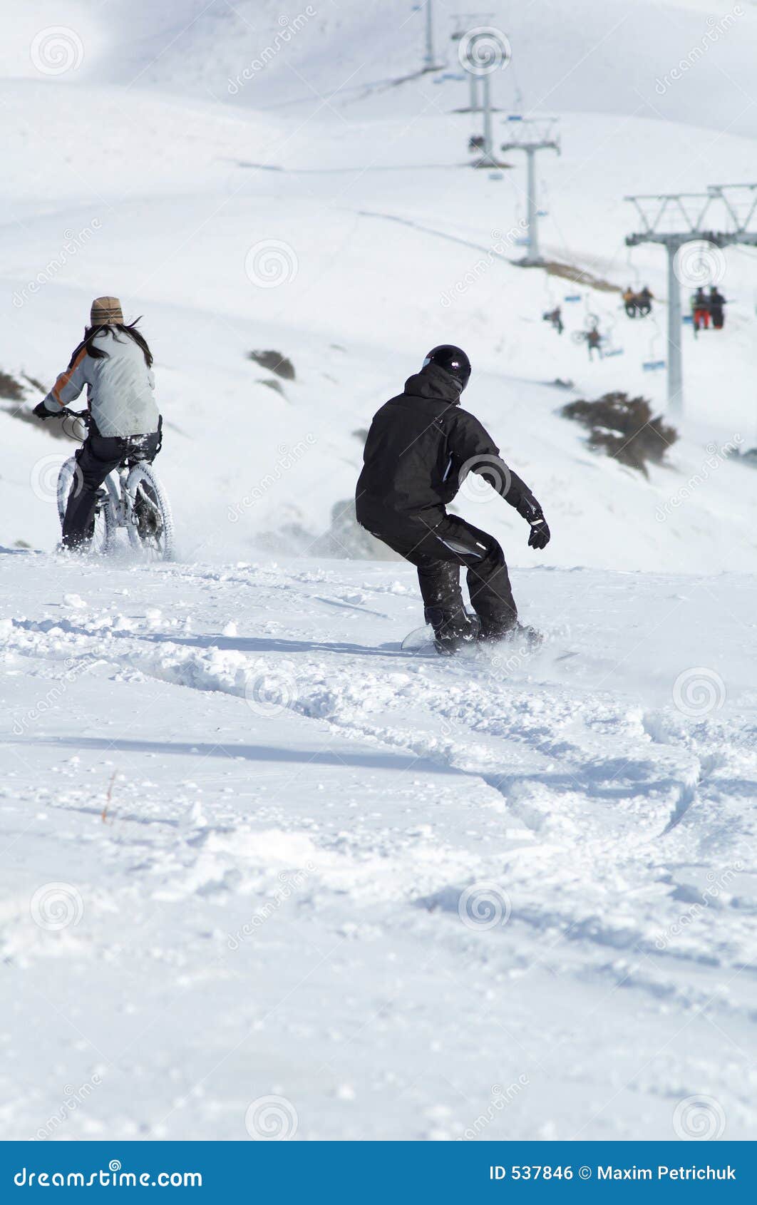 snowborder and biker downhill