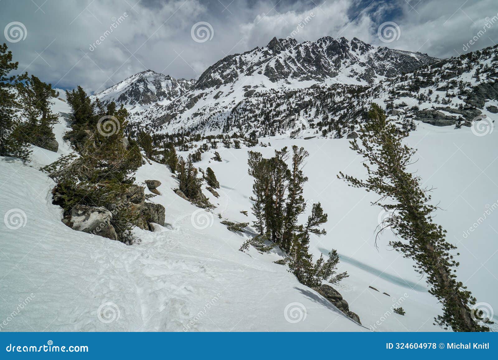 a snowy mountain range with a lake in the foreground