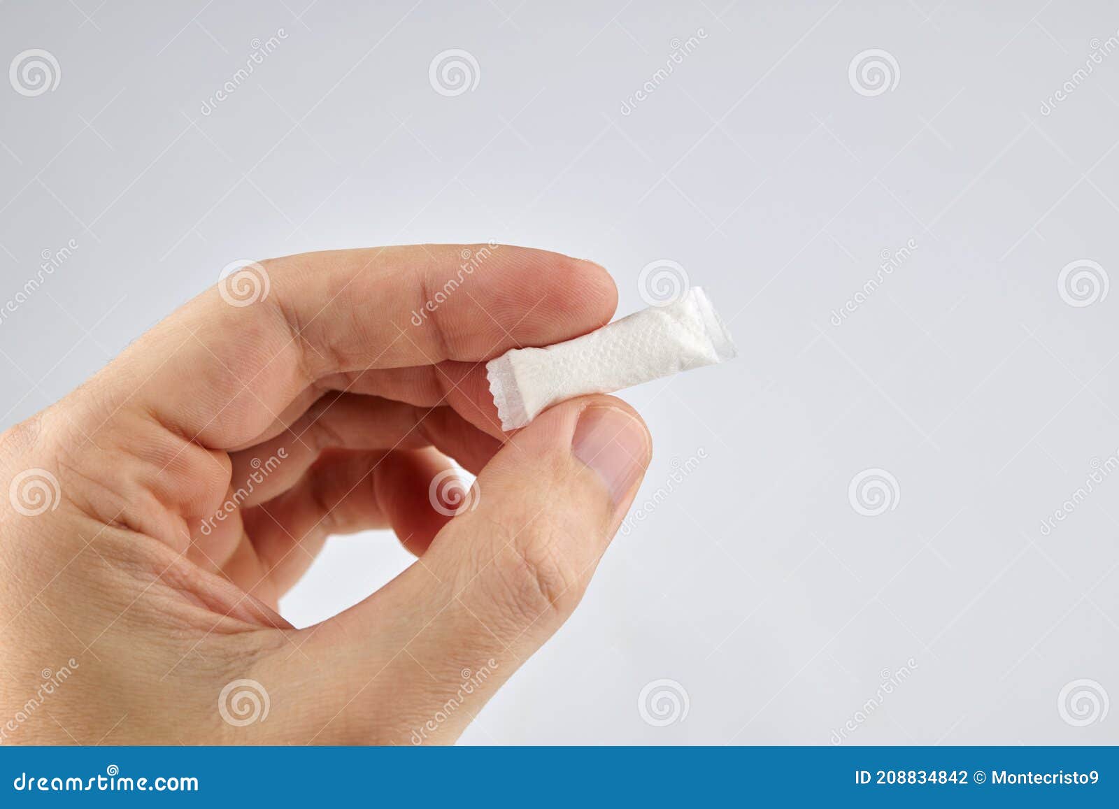 snus nicotine product at hand palm. copy space. stack of white small bags in the hand