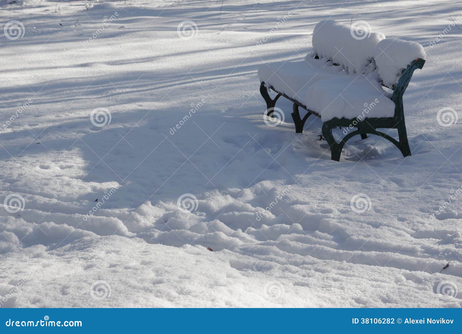 Snö-täckt bänk i en solig vinterdag. Töm dentäckte bänken i en solig vinterdag