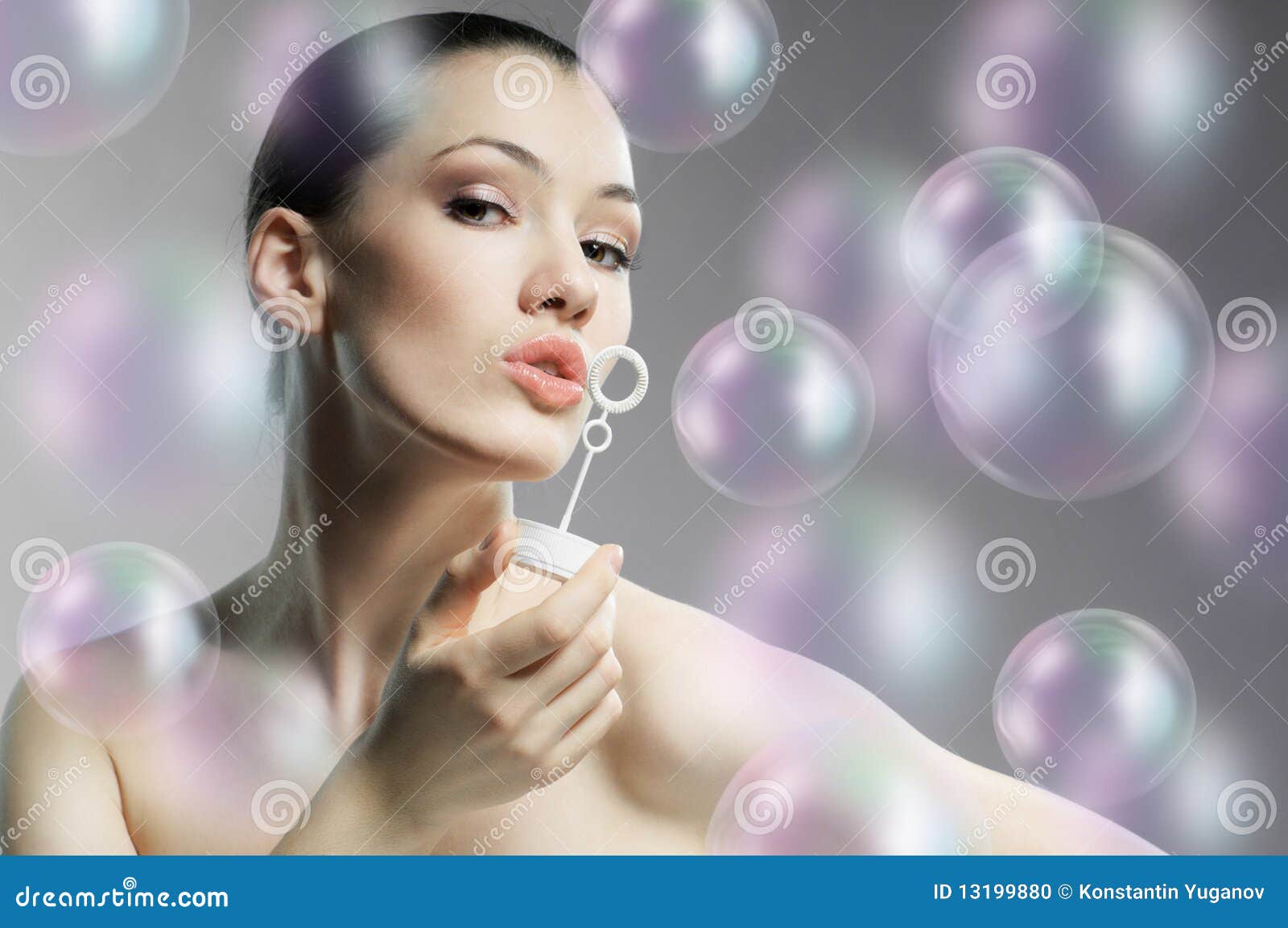 A beauty young woman blowing soap bubbles