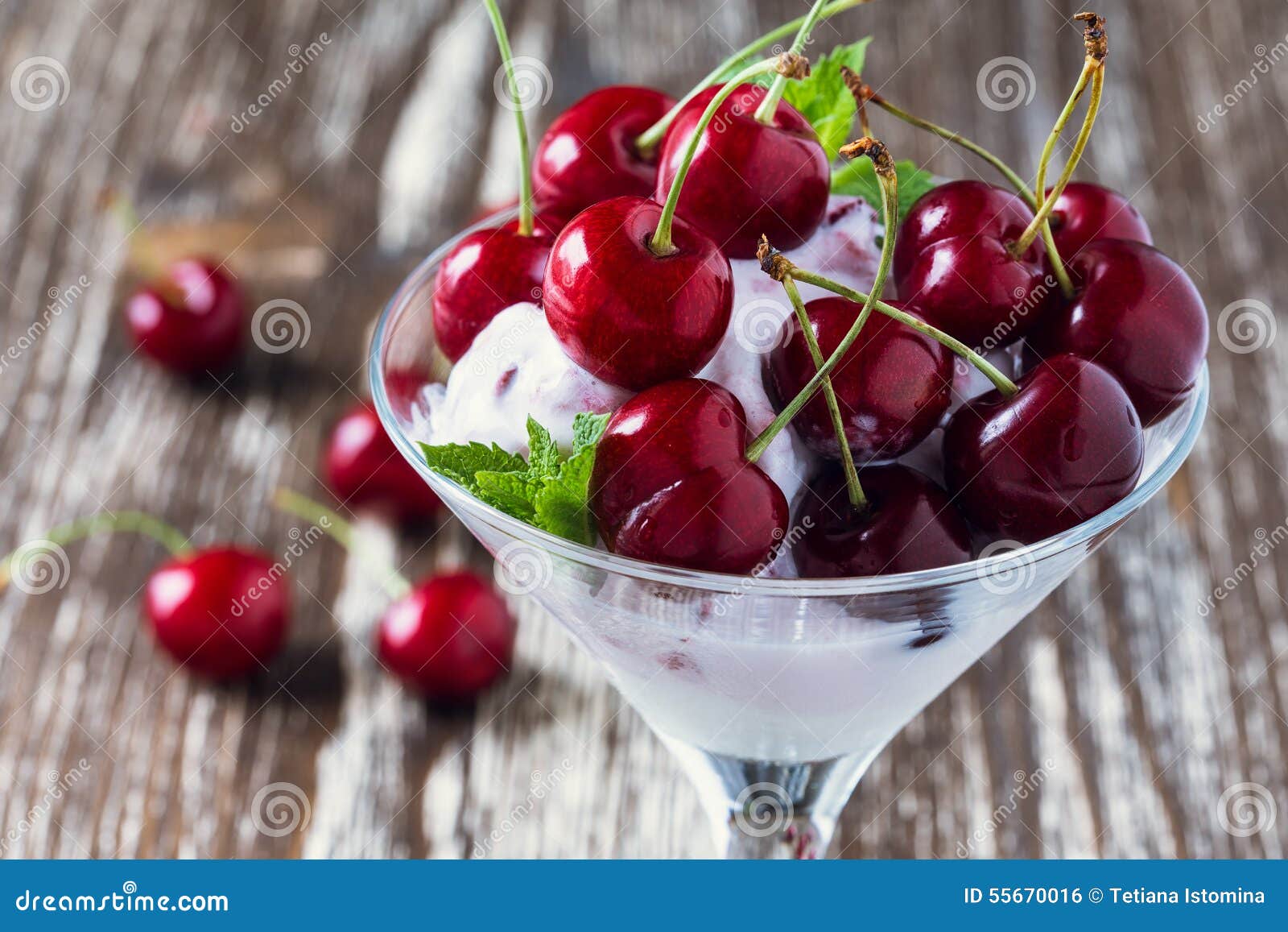 Sobremesa do gelado do fruto com a cereja doce no vidro de martini. Sobremesa macia congelada do gelado do fruto com a cereja doce na parte superior no vidro de martini no fundo chique gasto