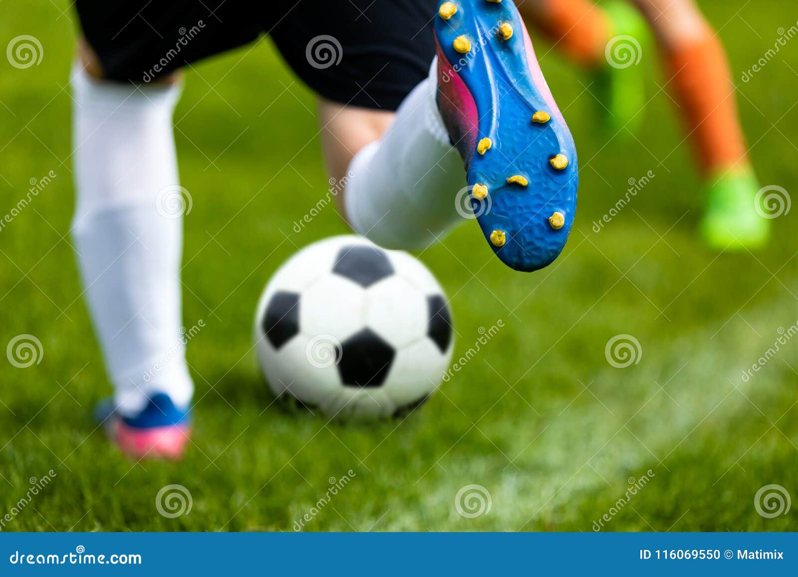 soccer kick. footballer kicking ball on grass pitch. football soccer player hits a ball