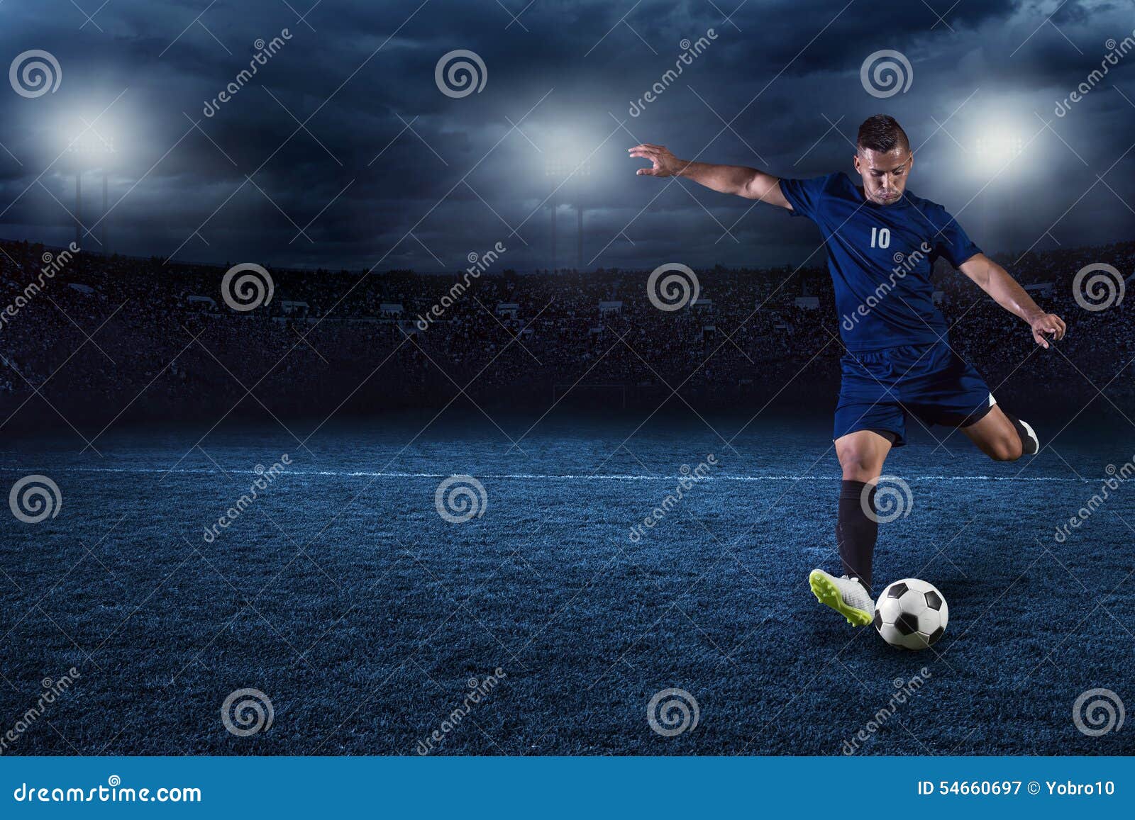 soccer player kicking ball in a large stadium at night