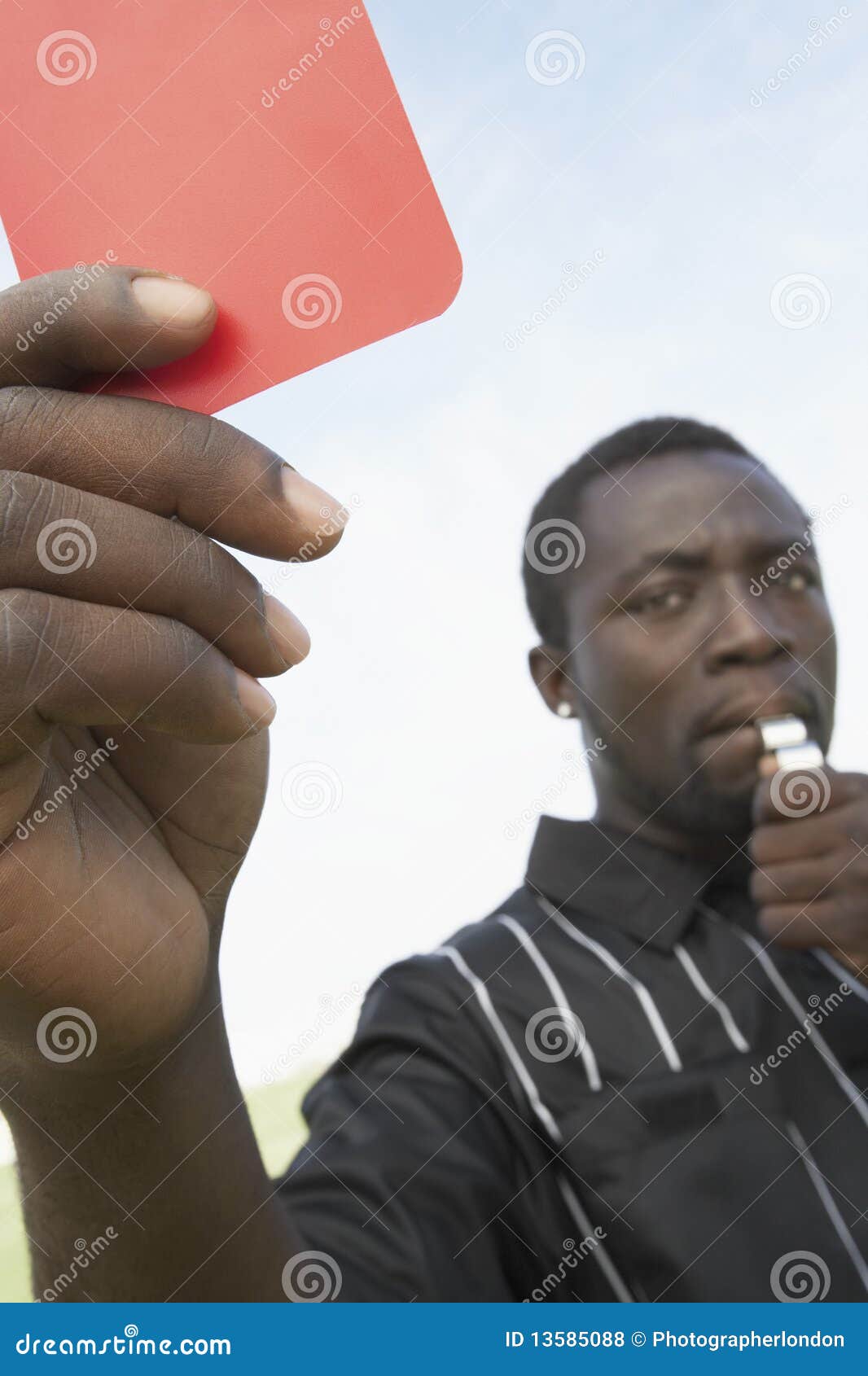 Soccer Referee Holding Out Red Card and Whistle Stock Photo