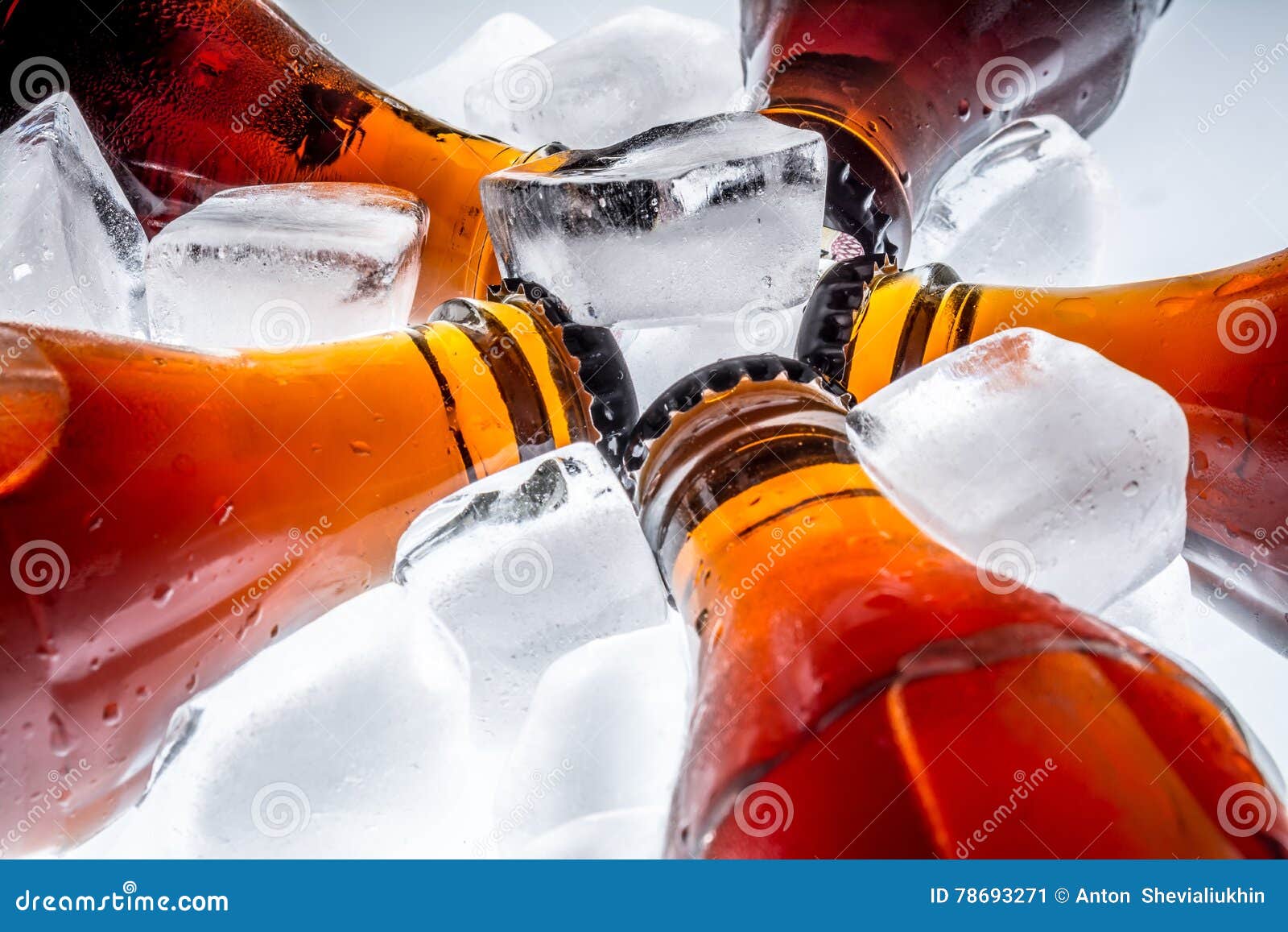 Soda Glass Bottles in a Refrigerated Ice Cubes on Light Background