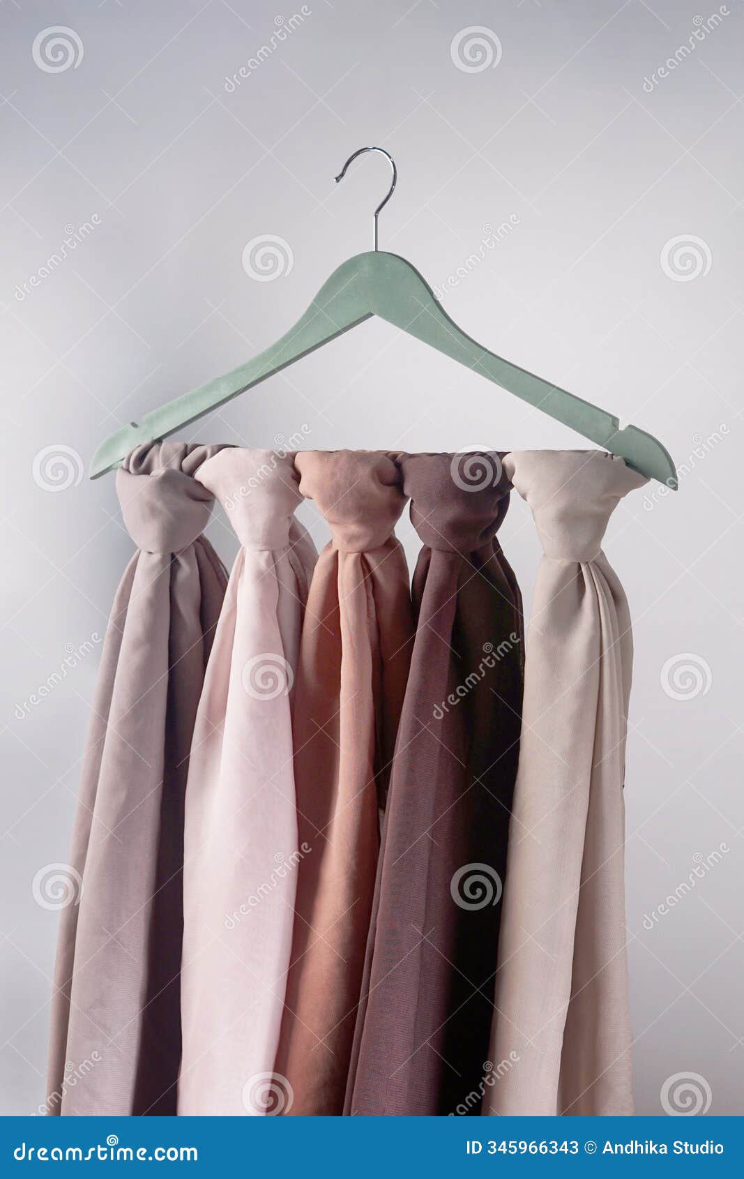 a soft colored hijab hanging in isolation on a white background.