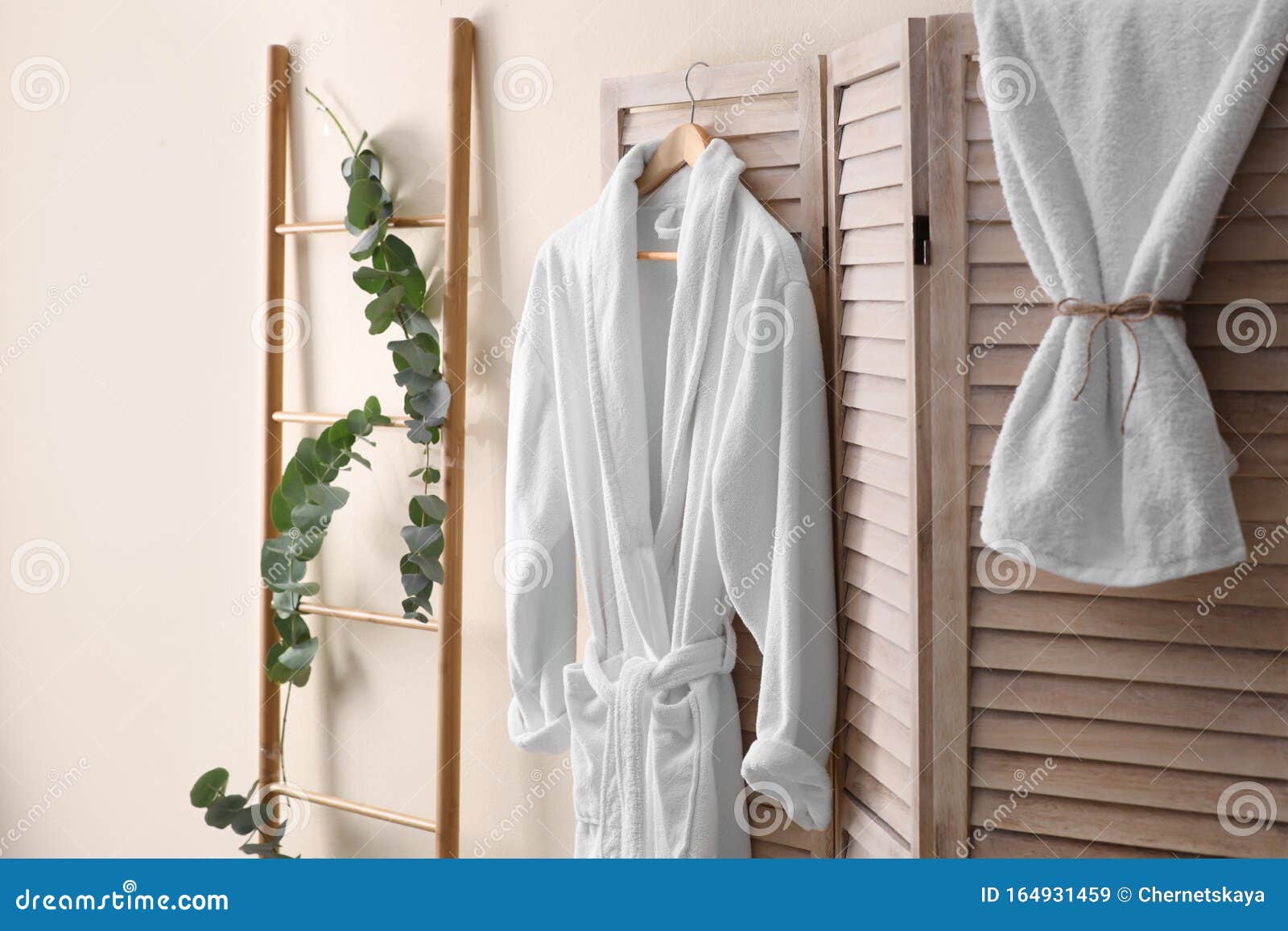 Soft Comfortable Bathrobe Hanging on Folding Screen in Room Interior