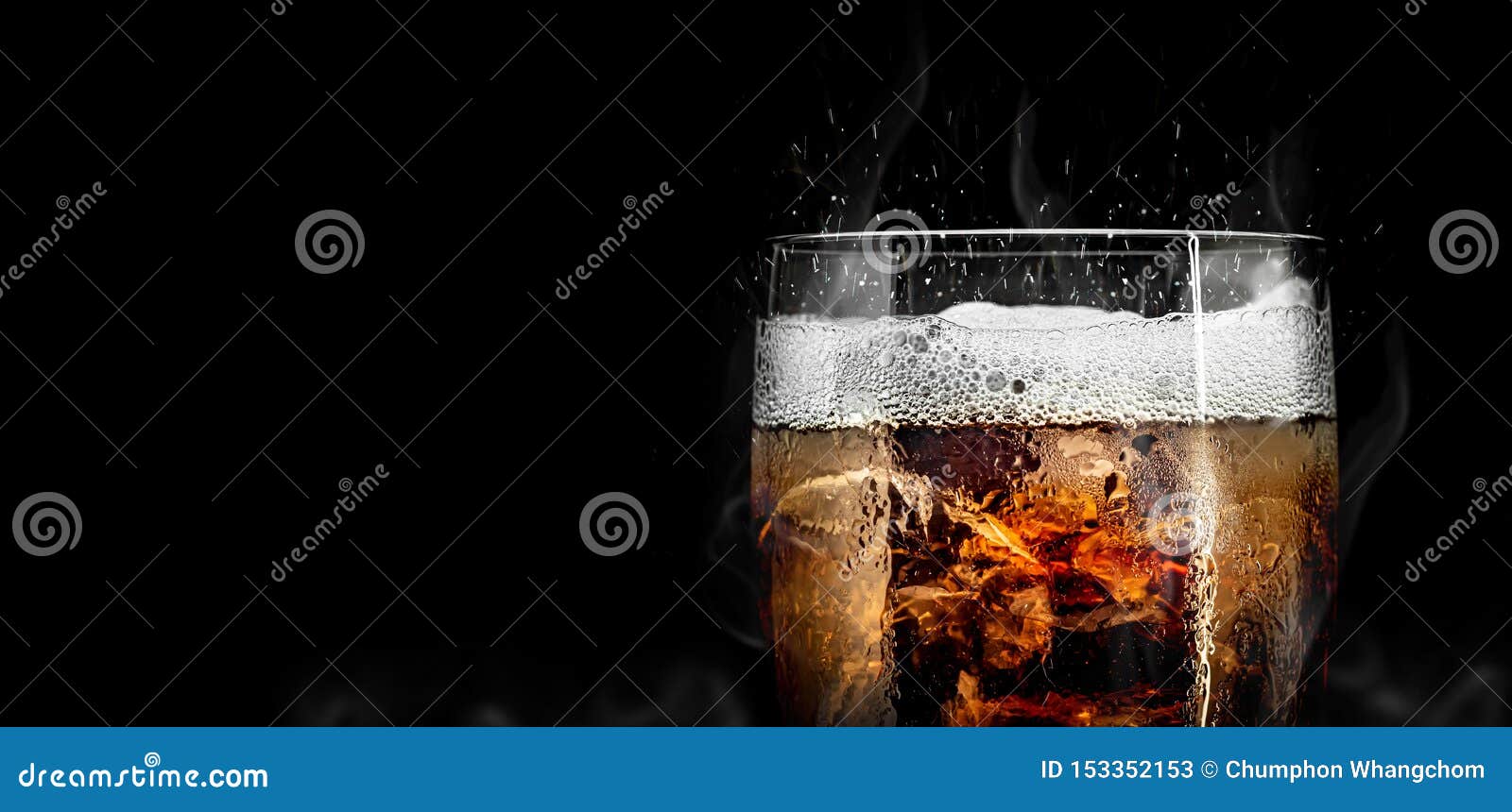 soft drink glass with ice splash on cool smoke background. cola glass with summer refreshment