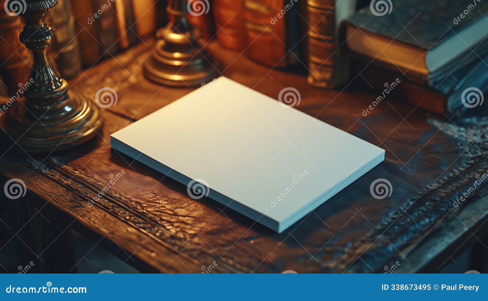vintage desk with blank stack of cards lit by lamp and surrounding books