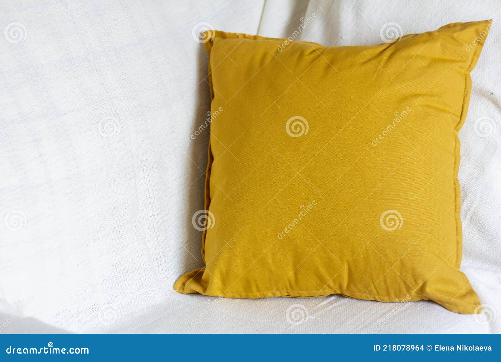 A Soft Yellow or Mustardcolored Pillow on a Cozy Sofa Stock Photo