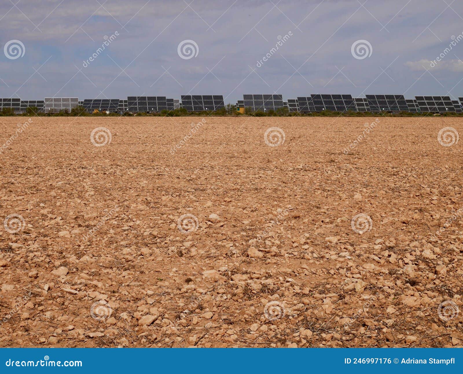 solar farm on red soil against blue sky in castile la mancha, spain.