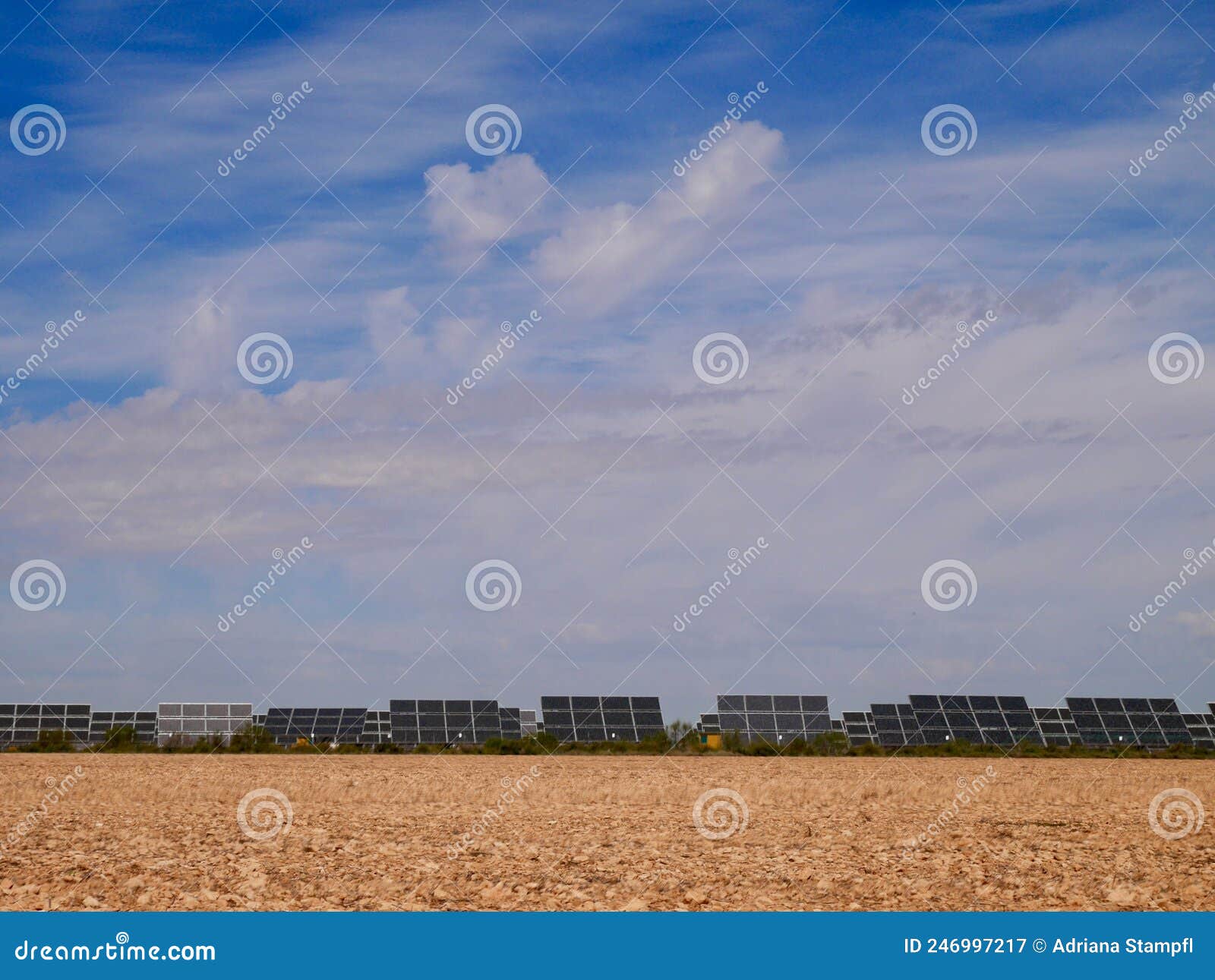 solar farm on red soil against blue sky in castile la mancha, spain.