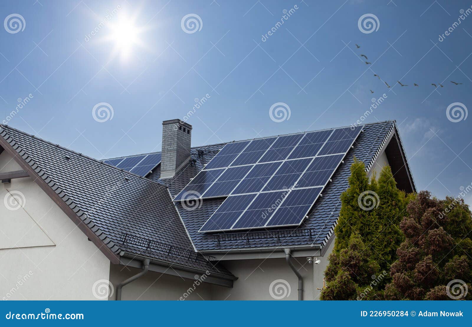 beautiful modern house with solar panels. clear sky, sun